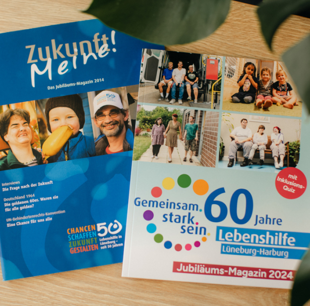 Jubiläums-Magazine 2014/2024 liegen nebeneinander auf einem Tisch.