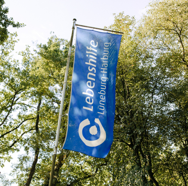 Eine Lebenshilfe-Fahne weht im Wind.