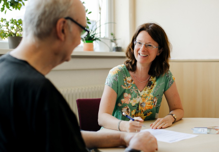Eine Frau berät einen Mann mit Behinderung.